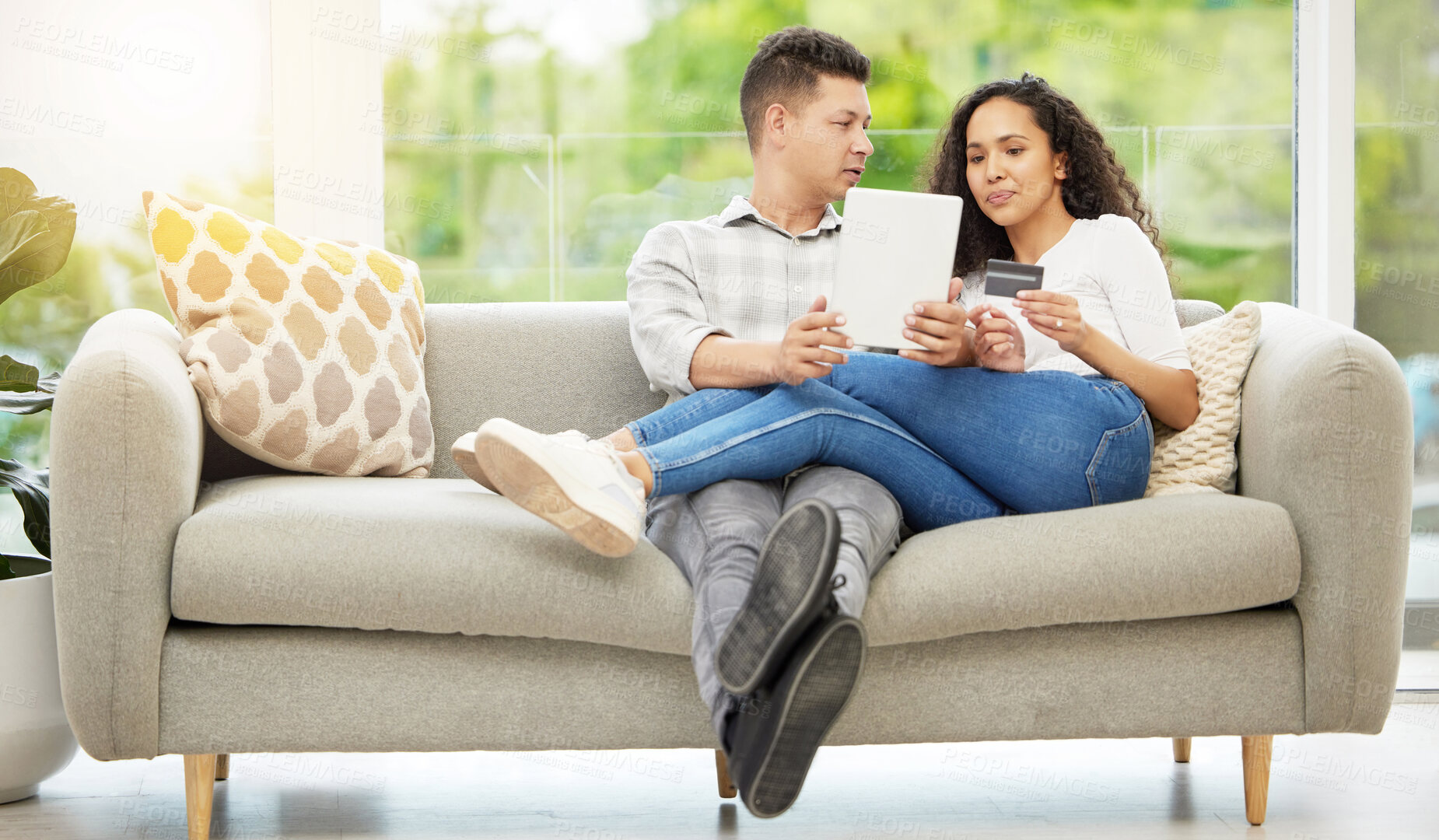 Buy stock photo Shot of a couple using a digital tablet and credit card on the sofa at home