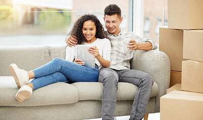 Buy stock photo Shot of a young couple bonding on the sofa while using a digital tablet