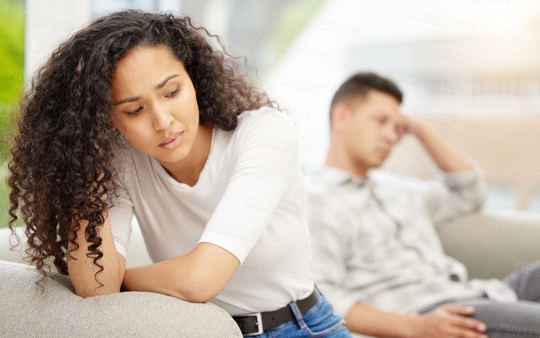 Buy stock photo Shot of a young couple sulking after an argument at home on a sofa