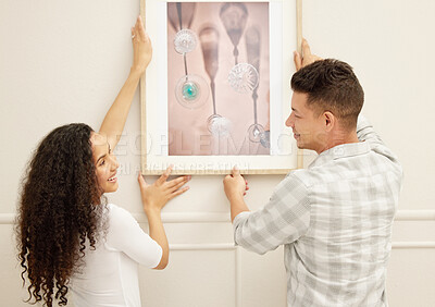 Buy stock photo Shot of a couple hanging art in their new home