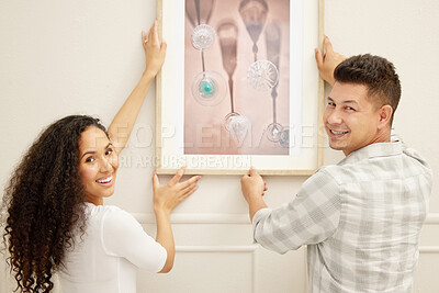 Buy stock photo Shot of a couple hanging art in their new home