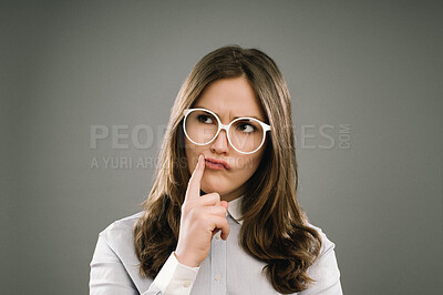 Buy stock photo Woman, student and thinking with glasses in studio for education, exam or assessment by background. Girl, nerd or person with ideas, confused and vision for studying, test and college for learning