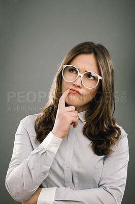 Buy stock photo Girl, student and thinking with glasses in studio for education, exam or assessment by background. Woman, geek or person with ideas, confused and vision for studying, test and college for learning
