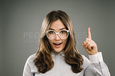 Buy stock photo Glasses, idea and portrait of girl nerd in studio on gray background for accessories or fashion. Aha, finger and inspiration cute geek or natural person in eyewear for retro or vintage style