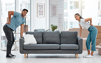 Buy stock photo Full length shot of a young couple standing and suffering from backache after moving their sofa at home