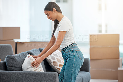 Buy stock photo Shot of an attractive young woman designing her sofa with pillows in her new home