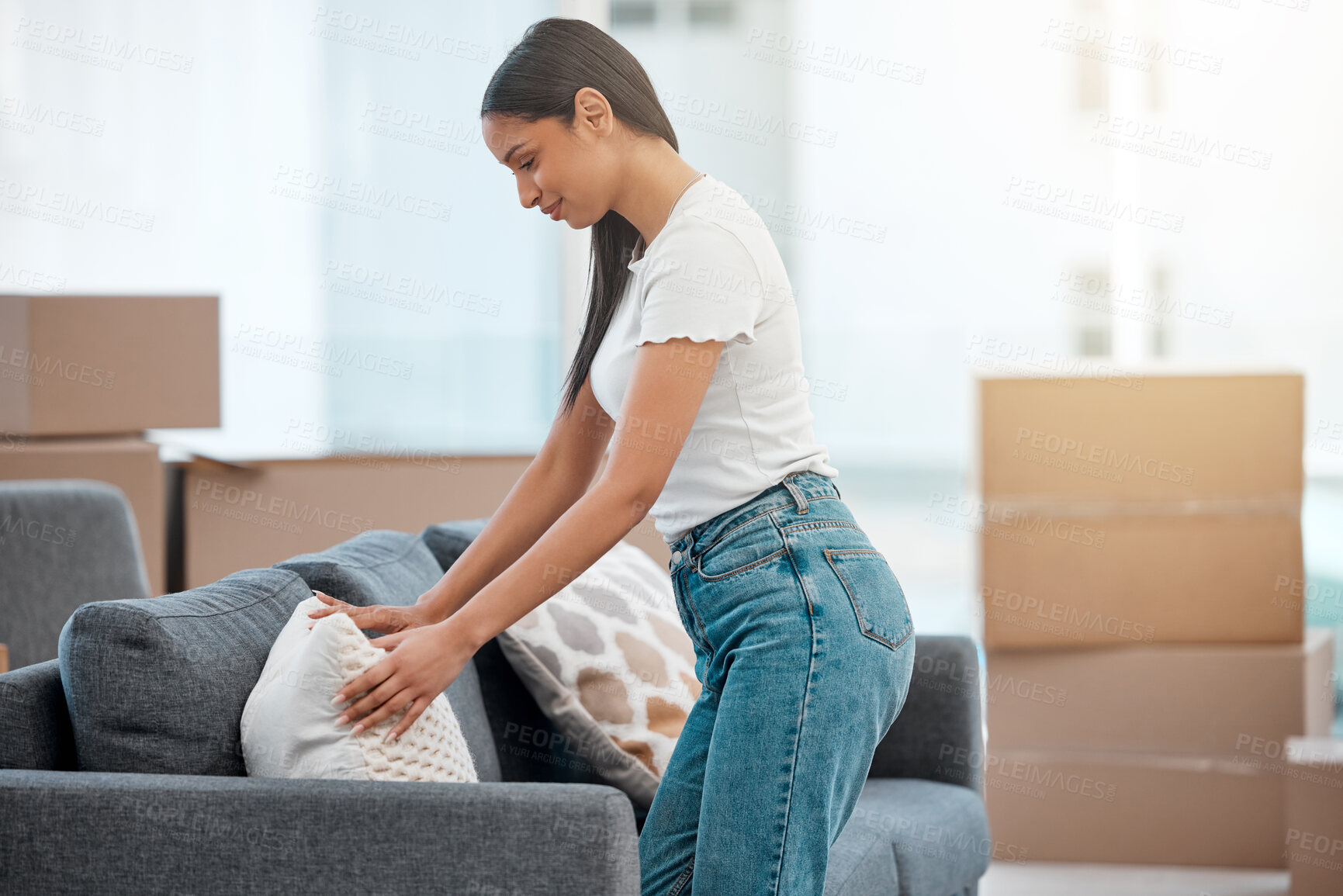 Buy stock photo Happy woman, pillow and moving in with boxes on sofa for new home, interior or furniture in living room. Female person with soft cushion, fabric or material in apartment for property or investment