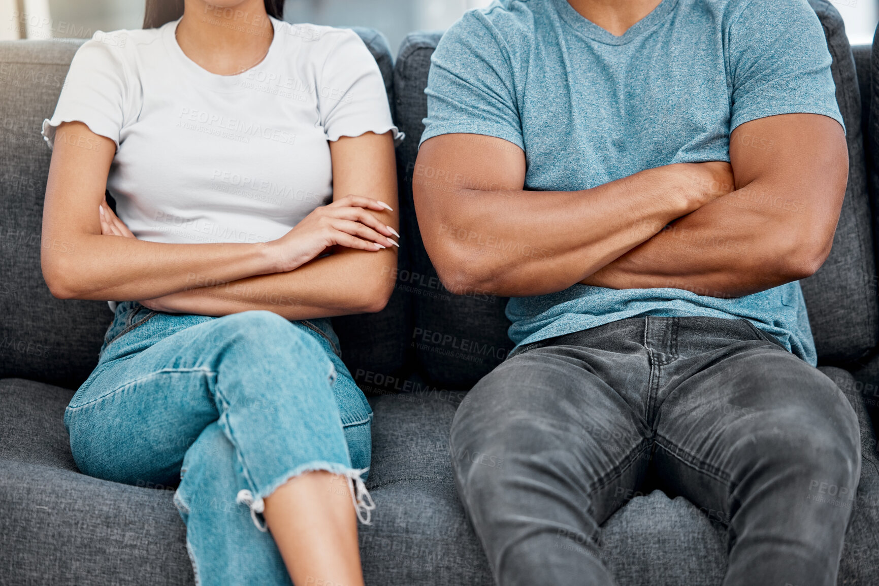 Buy stock photo Cropped shot of an unrecognisable couple sitting on the sofa with their arms crossed after a fight