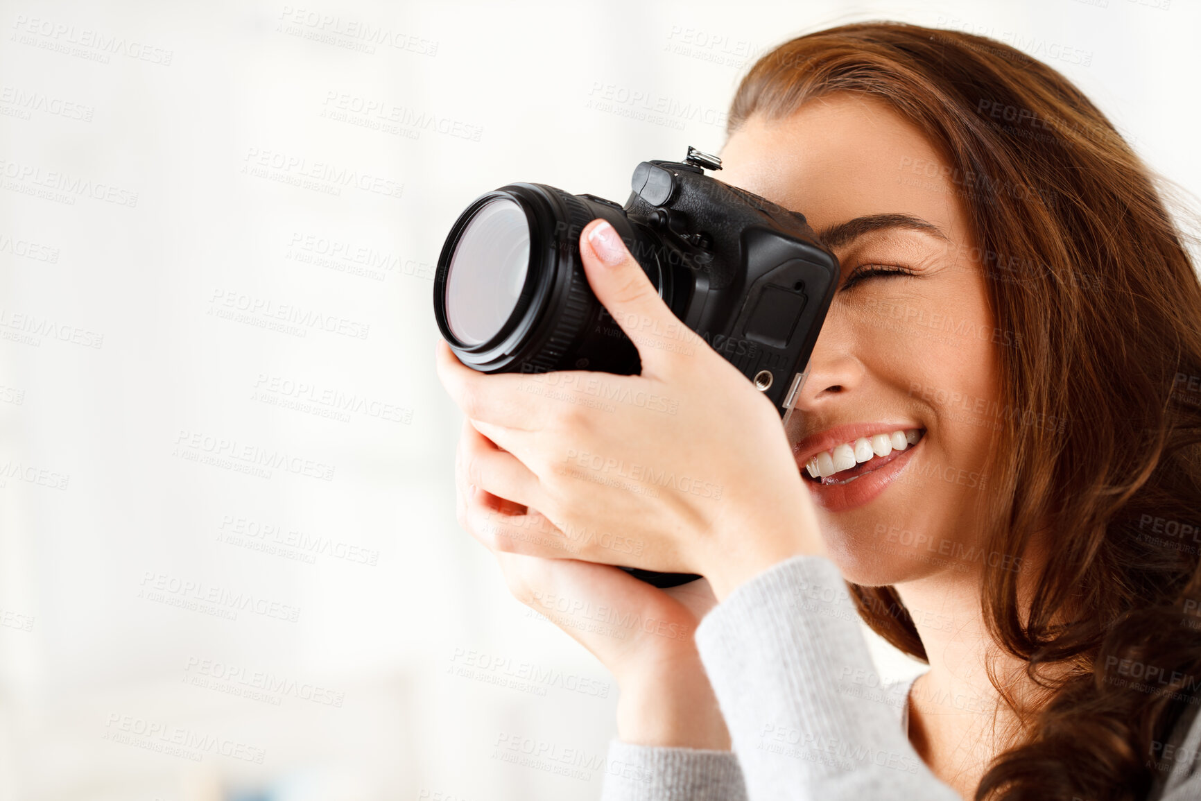 Buy stock photo Happy woman photographer doing a photoshoot with a camera in a studio with copy space. Art, creative and young lady with a photography career taking a picture for a artistic work project. 