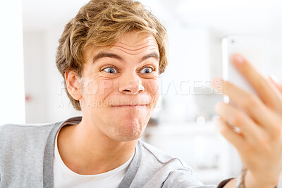 Buy stock photo Crazy, selfie and man online with funny post to social media, website or film silly video in home. Goofy, face and weird profile picture of gen z person in apartment with strange emoji or expression