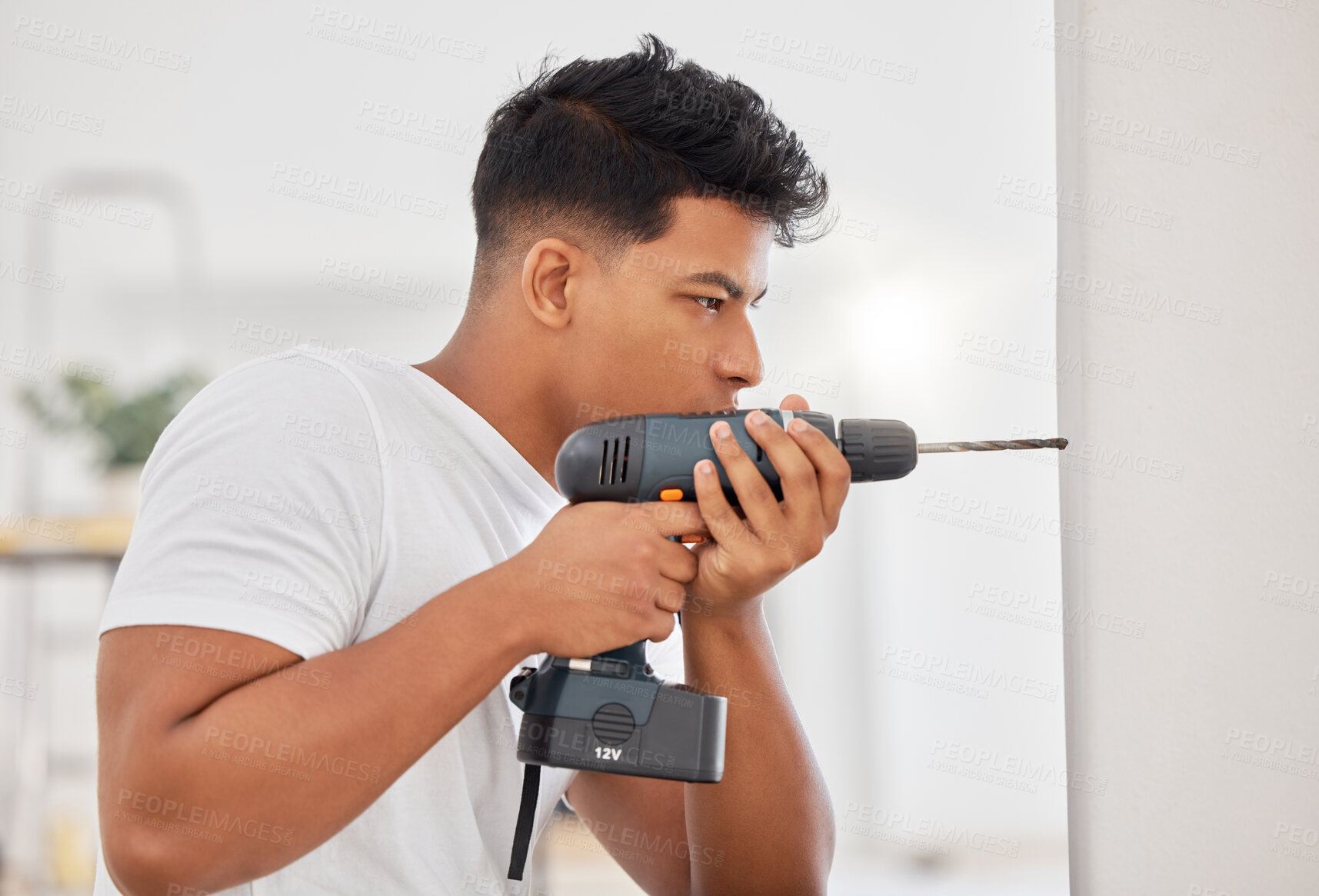 Buy stock photo Shot of a man using a cordless drill on a wall