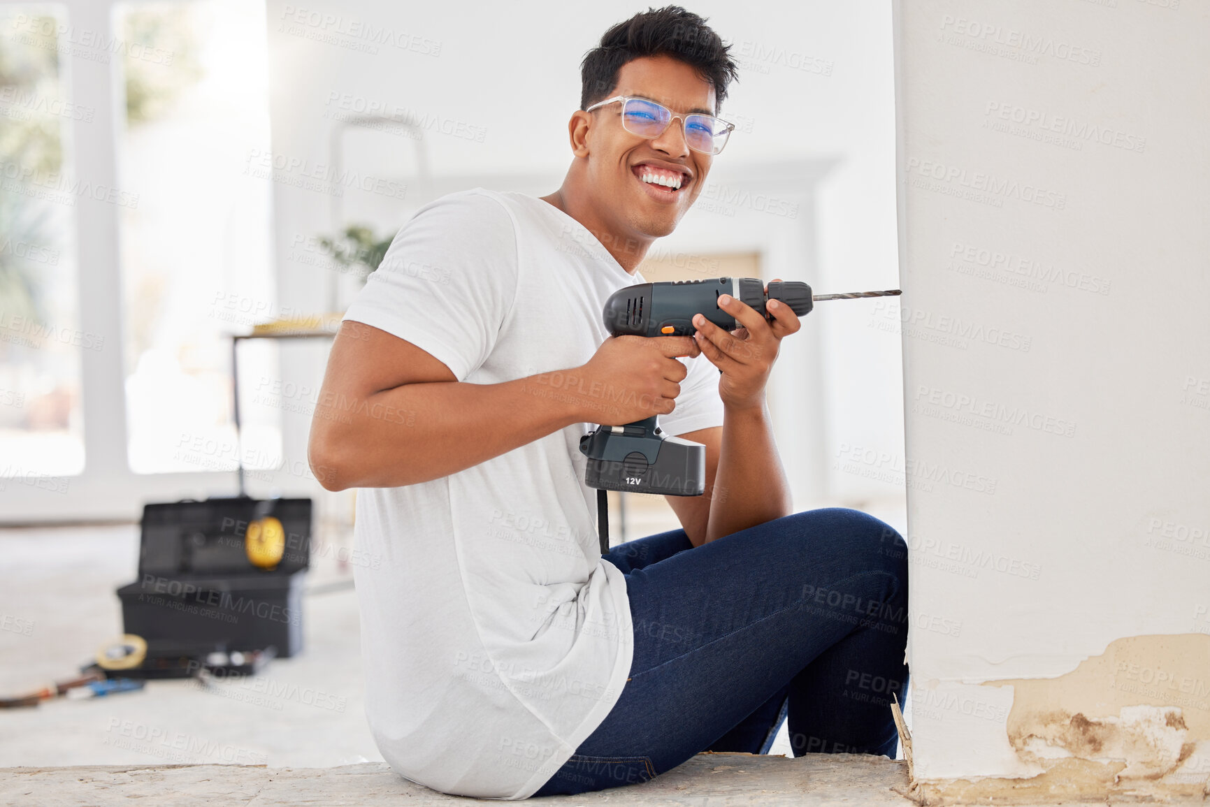 Buy stock photo DIY, drill and wall with portrait of man in home for construction, maintenance or renovation. Contractor, power tools and property with happy person in apartment for decorating or improvement