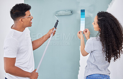 Buy stock photo Shot of a young couple looking at a color swatch while busy renovating a house