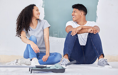 Buy stock photo Shot of a young couple painting a wall in a room together