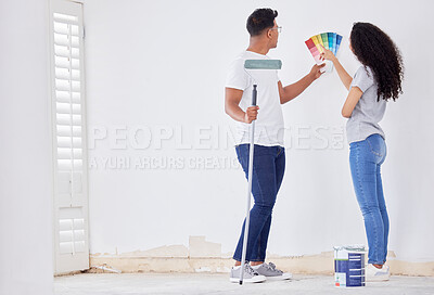 Buy stock photo Shot of a young couple looking at color swatches while painting a room