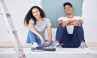 Buy stock photo Shot of a young couple painting a wall in a room together