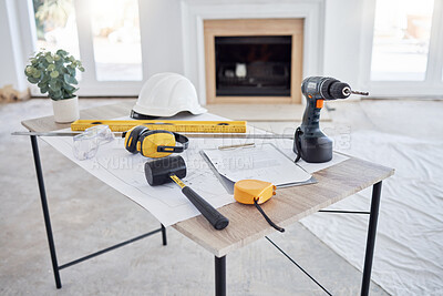 Buy stock photo Shot of building plans and equipment on a table in an empty living room during the day