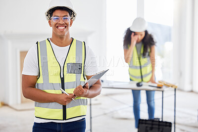 Buy stock photo Shot of a handsome young contractor standing inside and using a clipboard