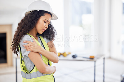 Buy stock photo Shot of an attractive young contractor standing alone inside and suffering from a shoulder injury