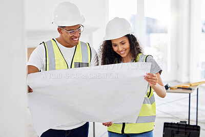 Buy stock photo Shot of two young contractors standing inside together and looking at building plans