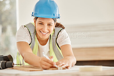 Buy stock photo Shot of an attractive young construction worker standing alone and using a ruler to measure a beam of wood