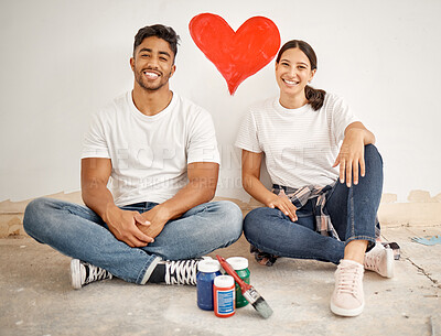 Buy stock photo Shot of a young couple painting a heart on a wall at home
