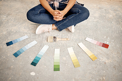 Buy stock photo Cropped shot of an unrecognizable woman sitting on the ground with a paintbrush and colour swatches