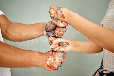 Buy stock photo Cropped shot of a young couple standing with their fists stacked while painting