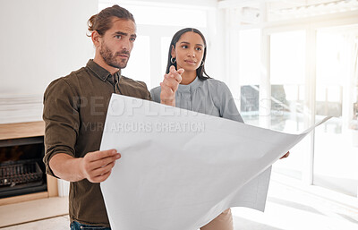 Buy stock photo Shot of two young architects looking at building plans on site