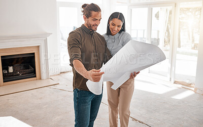 Buy stock photo Shot of two young architects looking at building plans on site
