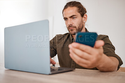 Buy stock photo Shot of a young businessman using a laptop in an office at work