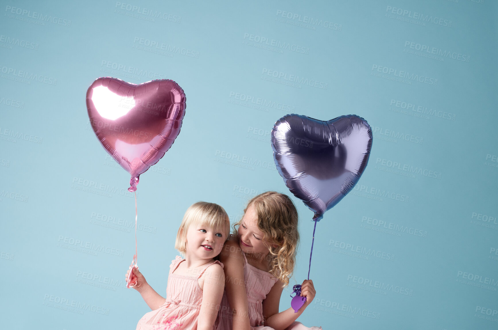 Buy stock photo Love, children and sister with heart balloon in studio on blue background for family or party. Birthday, celebration or smile with cute girls, happy on color backdrop together for youth event