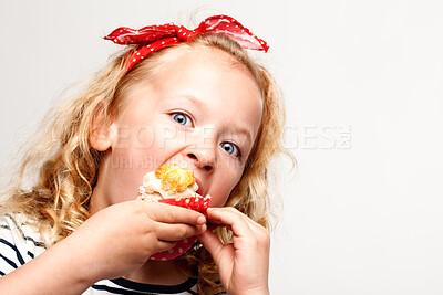 Buy stock photo Eating, cupcake and portrait of child in studio for dessert, sweet treat or sugar snack with white background. Bite, tasting and girl with vanilla cake for confection, hungry and enjoy delicious food