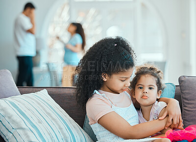 Buy stock photo Shot of a little girl comforting her little sister while their parents argue in the background
