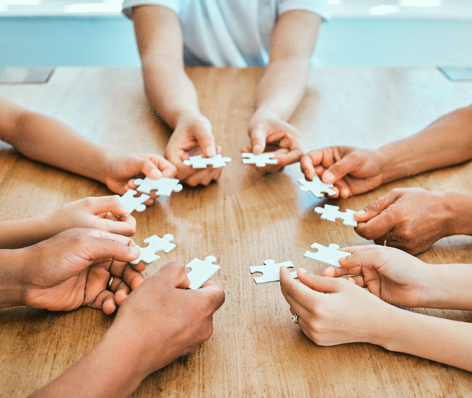 Buy stock photo Collaboration, hands and puzzle with business people at wooden table from above for teamwork. Building, effective or synergy and employee with jigsaw pieces for development, growth or planning