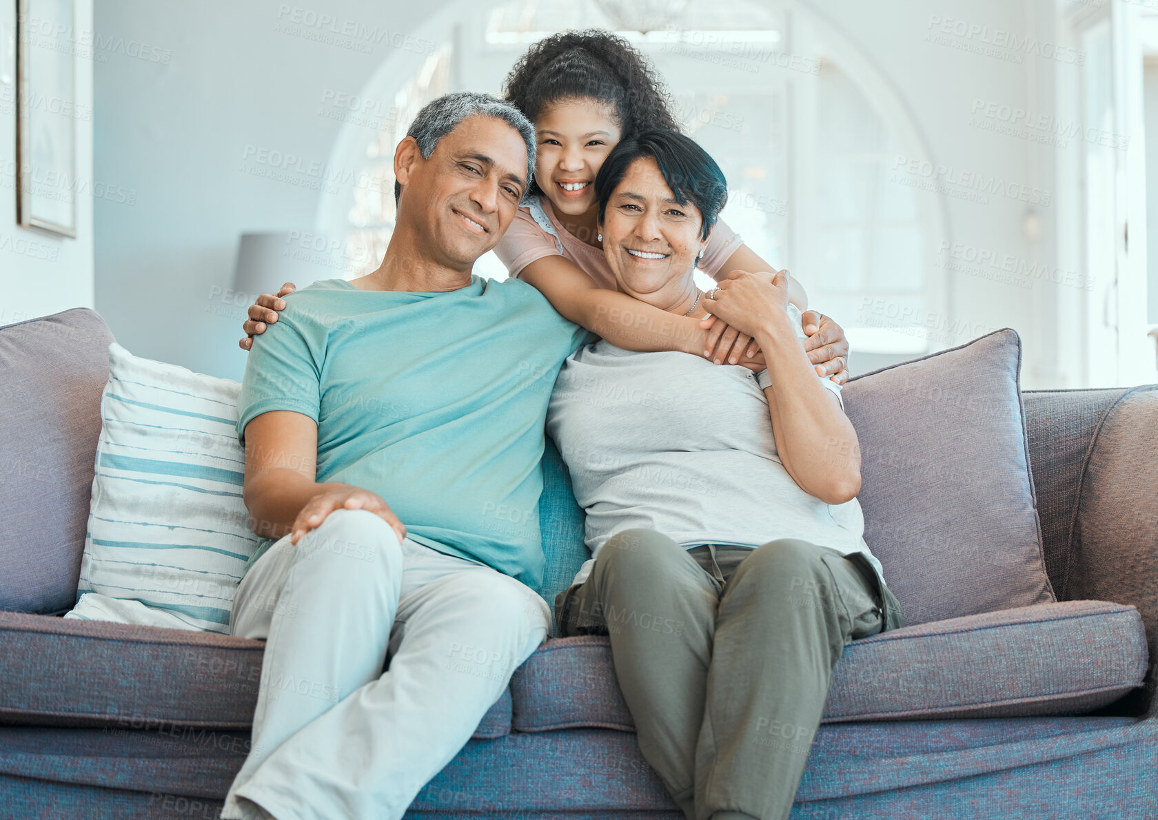 Buy stock photo Grandparents, kid and hug in portrait on couch with happiness, love and support in home. Family, care and smile together in living room, apartment or relax on sofa in house with senior couple