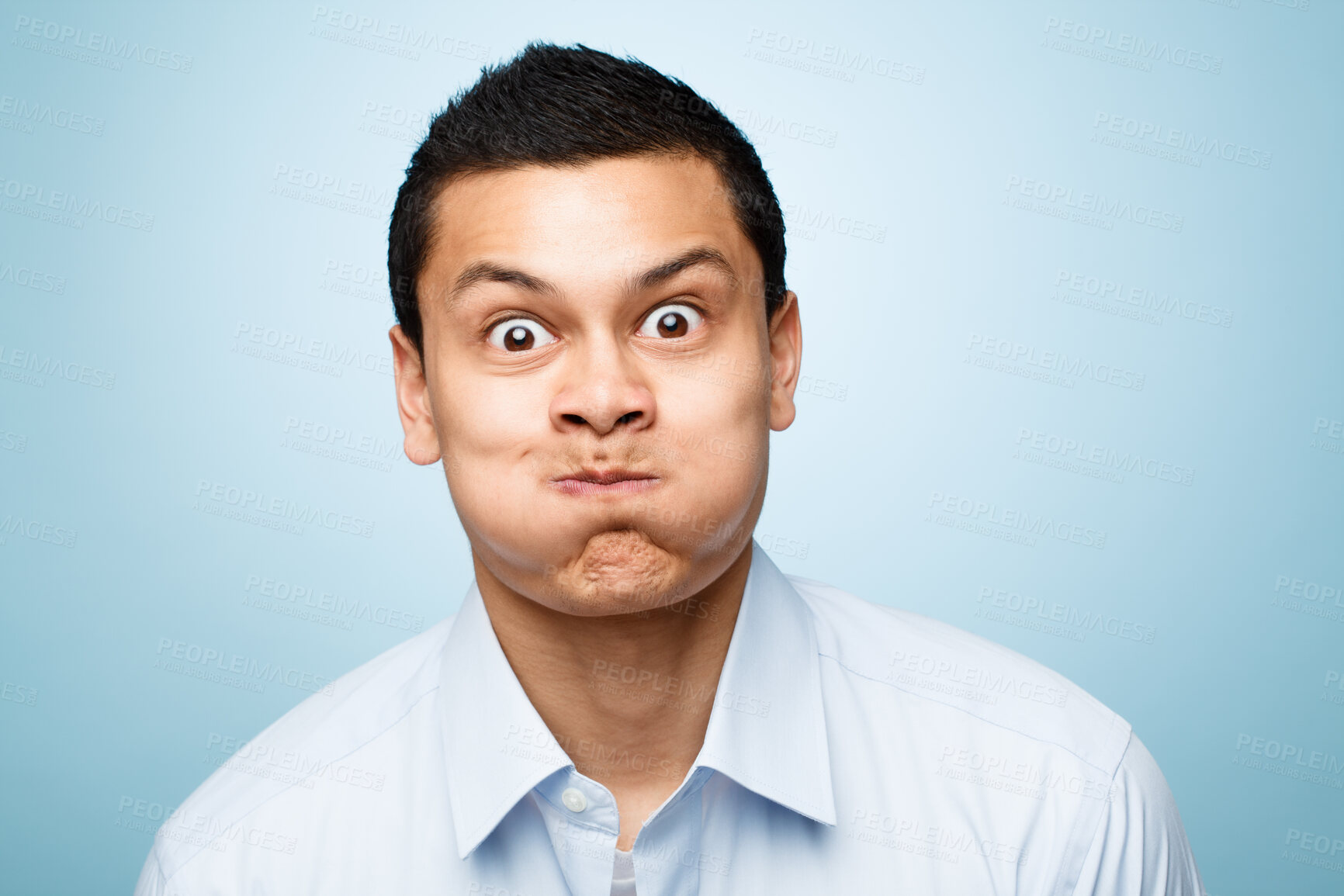 Buy stock photo Comic, portrait of man with blowing cheeks and against a blue background. Blown mouth or mockup, surprised or fun and isolated male person with funny face expression against a studio backdrop