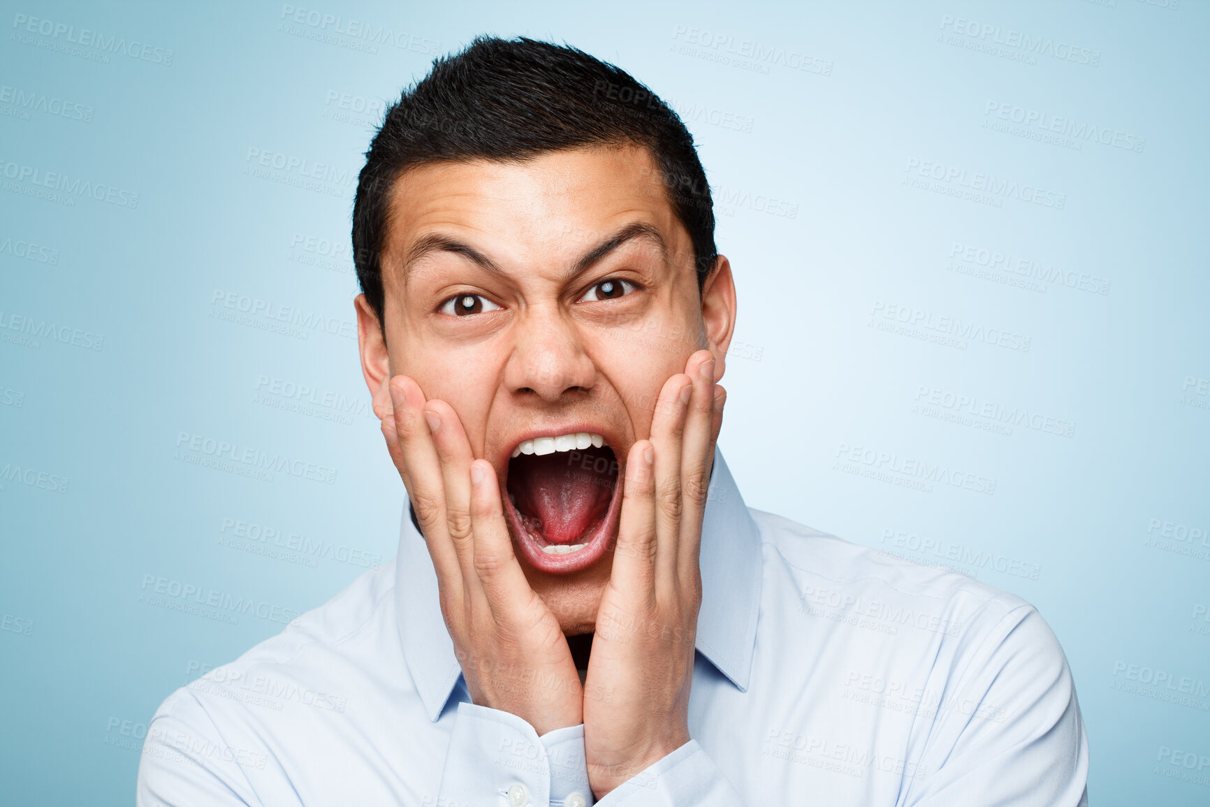 Buy stock photo Portrait, screaming and man with surprise, excited and expression on blue studio background. Face, person and model with shock, shouting or wow with emotion, reaction or omg with celebration or smile