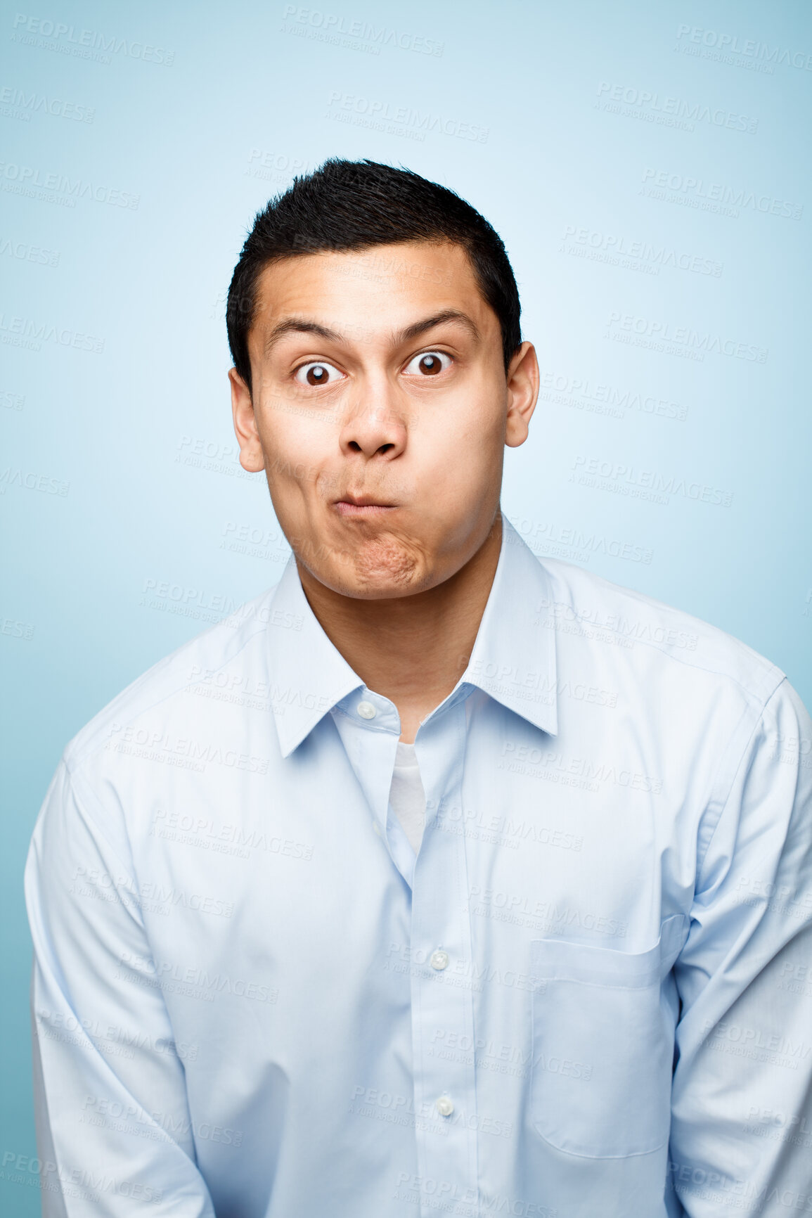 Buy stock photo Funny face, goofy and portrait of comic man in studio isolated on blue background for expression. Comedy, humor and joking with playful or silly business person having fun in shirt for fashion