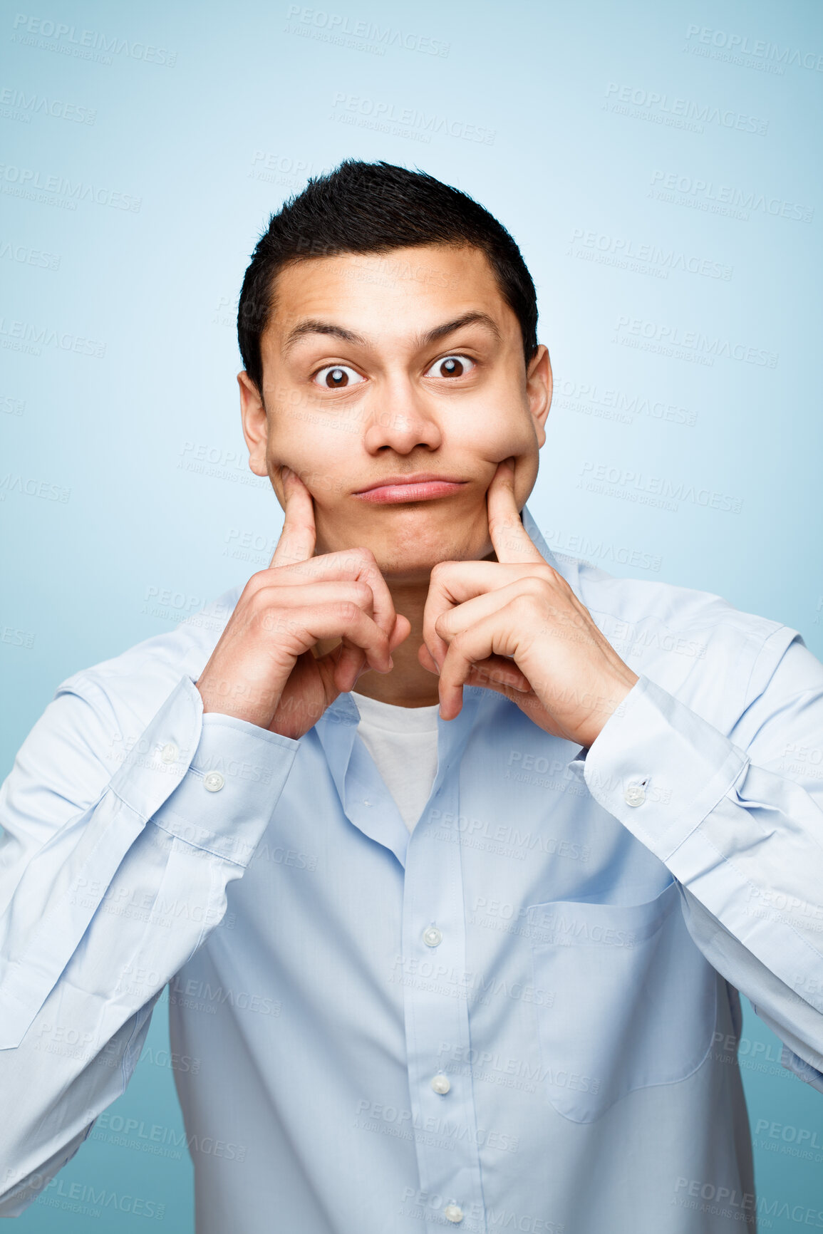 Buy stock photo Man, hands and facial expression for portrait in studio as creative comedian with funny gesture for amusement. Playful, male person and comedy as career on blue background for humour with jokes