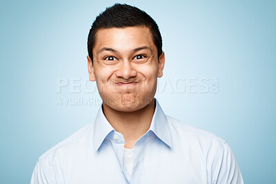 Buy stock photo Funny face, portrait and silly with comic man in studio isolated on blue background for expression. Comedy, humor and joking with goofy or playful business person having fun in shirt for fashion