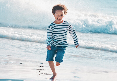 Buy stock photo Shot of an adorable little boy running on the beach
