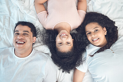 Buy stock photo Portrait of a beautiful young family talking and bonding in bed together