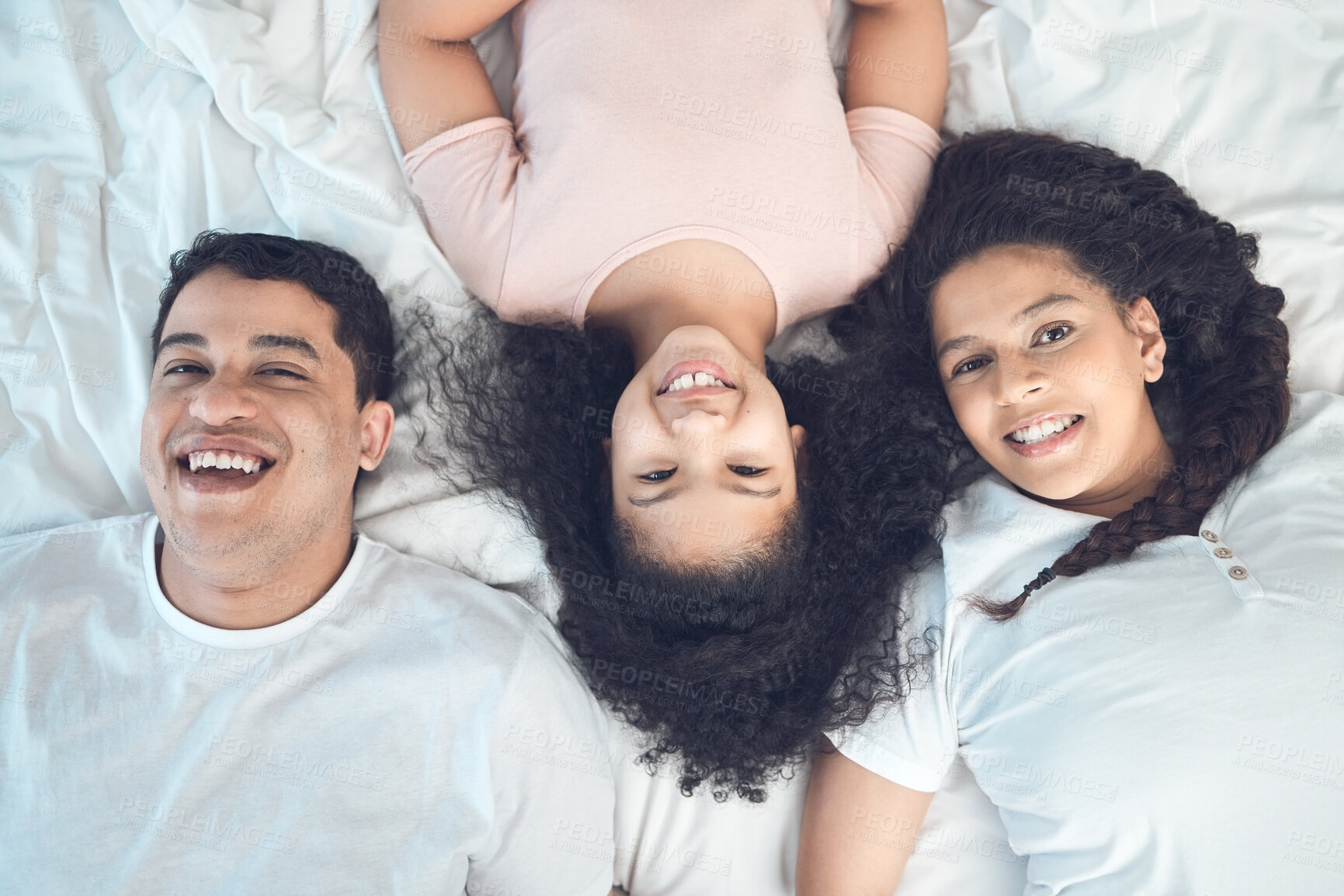 Buy stock photo Portrait of a beautiful young family talking and bonding in bed together