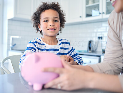 Buy stock photo Shot of a young mother teaching her son about savings at the kitchen table