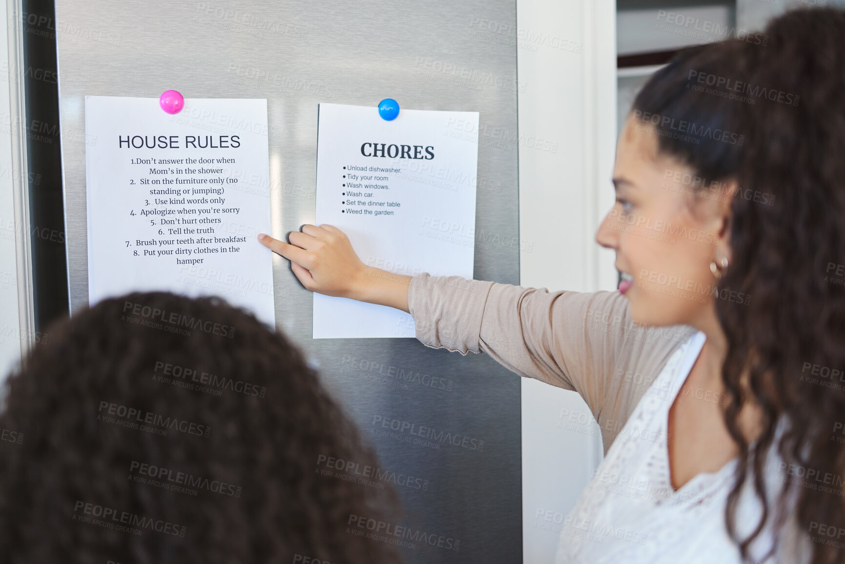 Buy stock photo Shot of a mother explaining a list of chores to her daughter at home