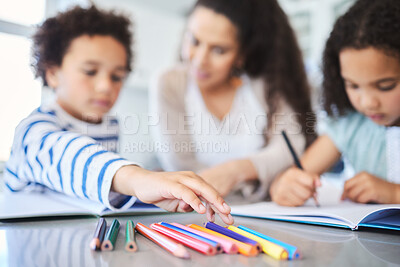 Buy stock photo Shot of a mother helping her kids with homework at the kitchen table