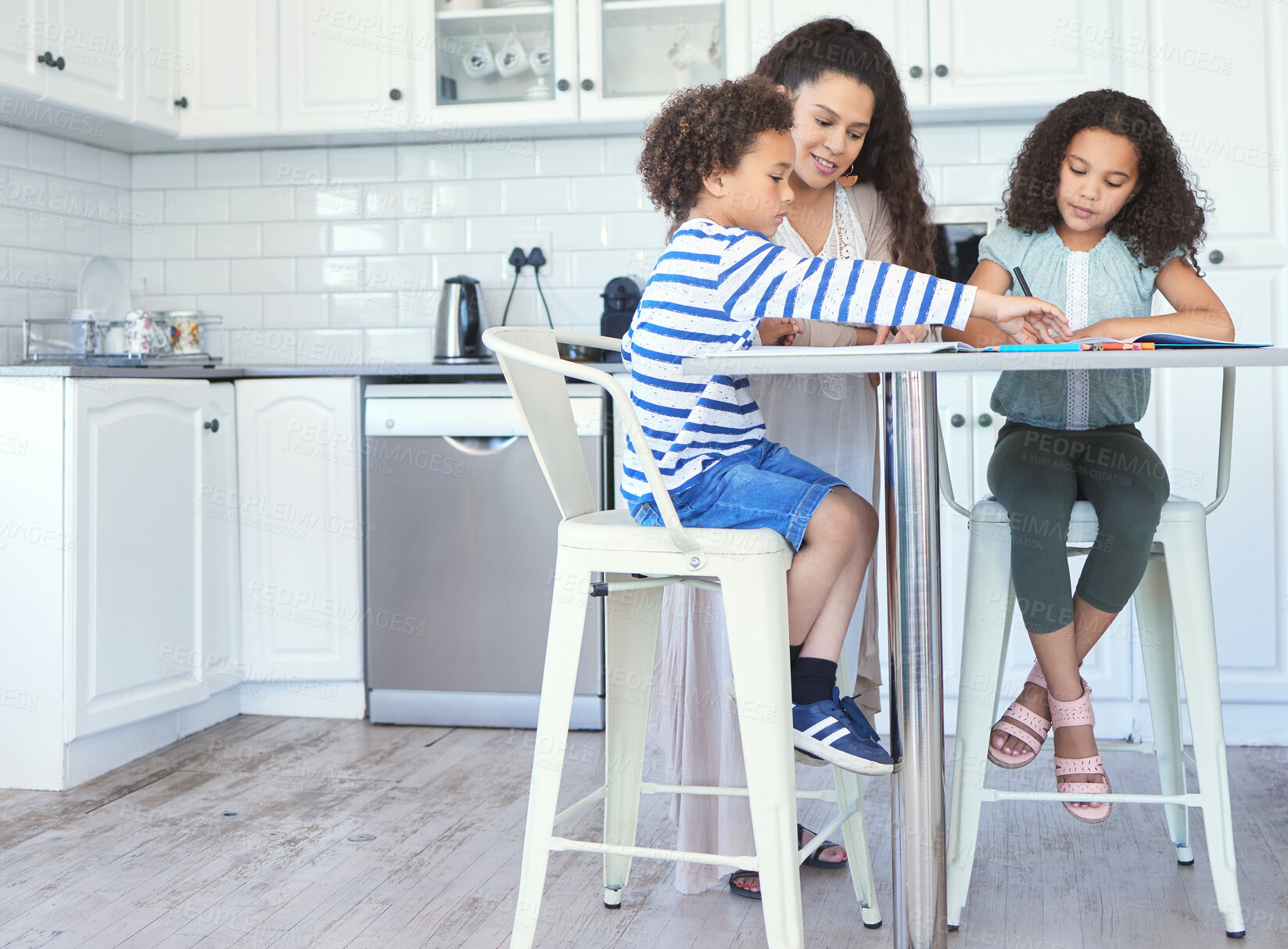 Buy stock photo Shot of a mother helping her kids with homework at the kitchen table