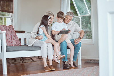 Buy stock photo Shot of grandparents bonding with their grandkids on the sofa at home