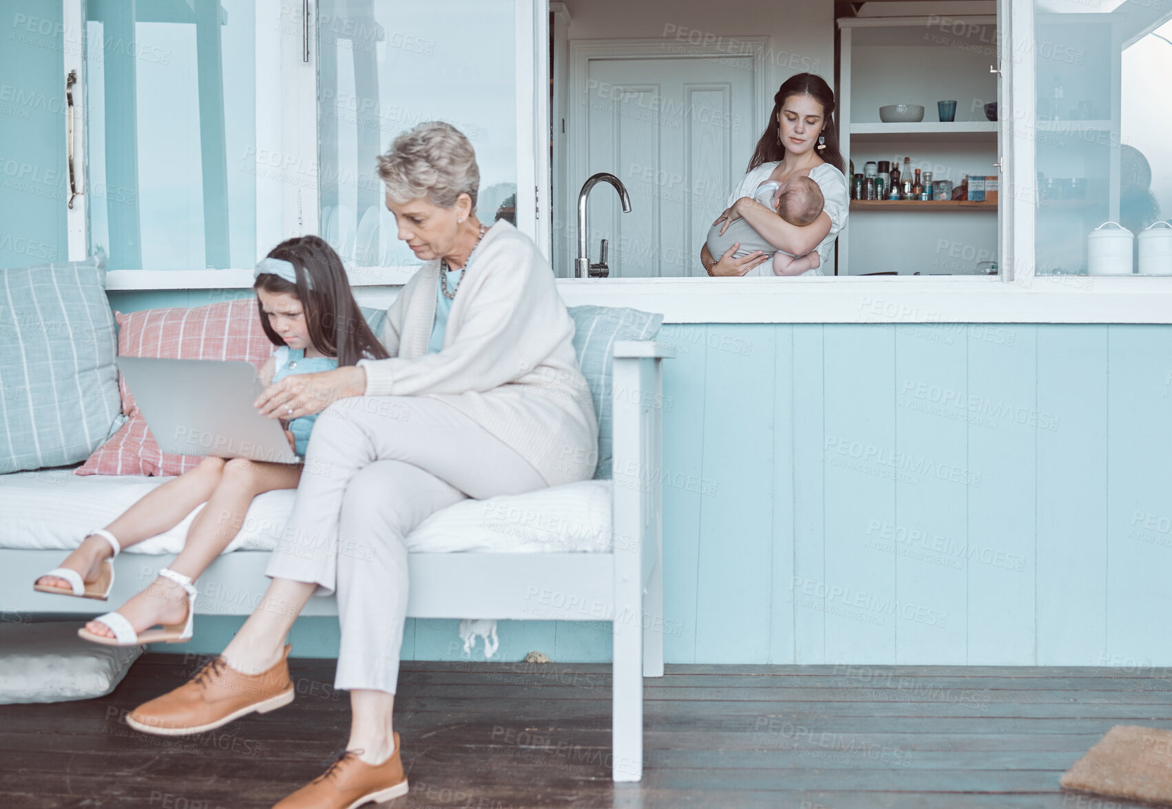 Buy stock photo Shot of a mature woman bonding with her granddaughter while a mother holds her newborn in the background